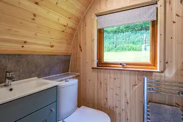 Glamping pod ensuite toilet with hand basin and heated towel rail