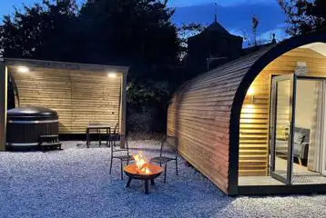 Glamping pod at night with woodfired hot tub and fire pit Glamping pod at night with woodfired hot tub and fire pit