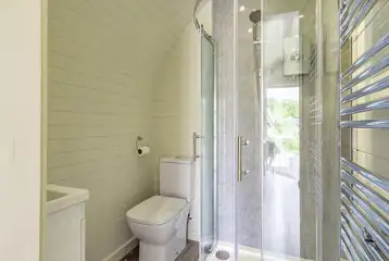 Glamping pod ensuite with toilet, shower, and towel rail 