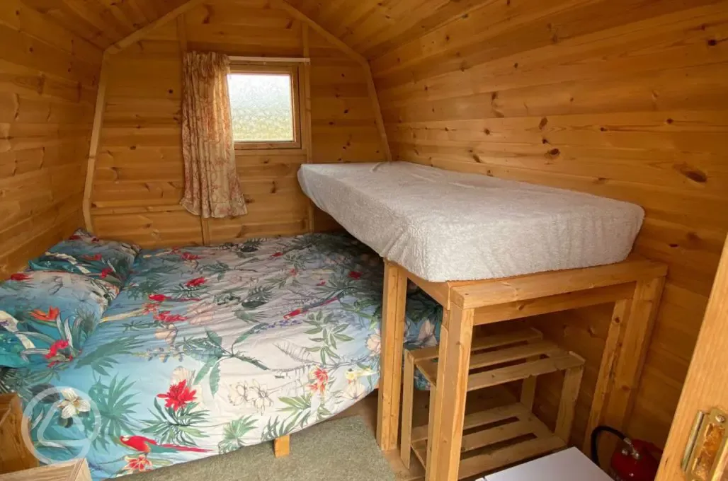 Log pod interior with double bed and bunk bed Log pod interior with double bed and bunk bed