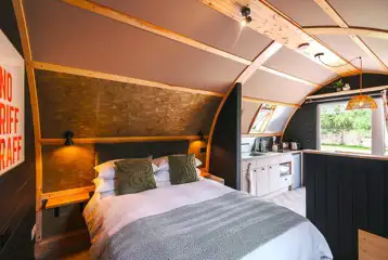 Quarry pod interior with double bed and kitchenette Quarry pod interior with double bed and kitchenette