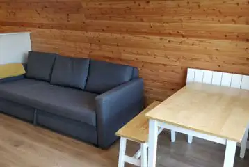 The Den and Roost glamping pod seating and dining area with sofa bed The Den and Roost glamping pod seating and dining area with sofa bed