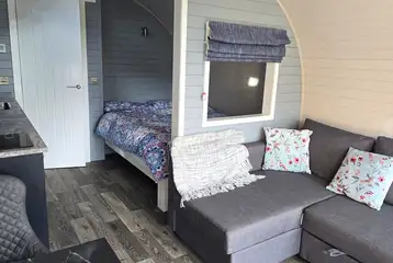 The Nest glamping pod interior with double bed and sofa bed The Nest glamping pod interior with double bed and sofa bed