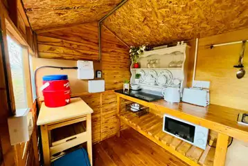 Old stables glamping cabin kitchen area with a kettle, microwave, and toaster