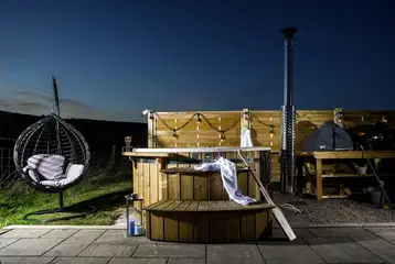 White Clover ensuite pod wood-fired hot tub with fairy lights at night White Clover ensuite pod wood-fired hot tub with fairy lights at night