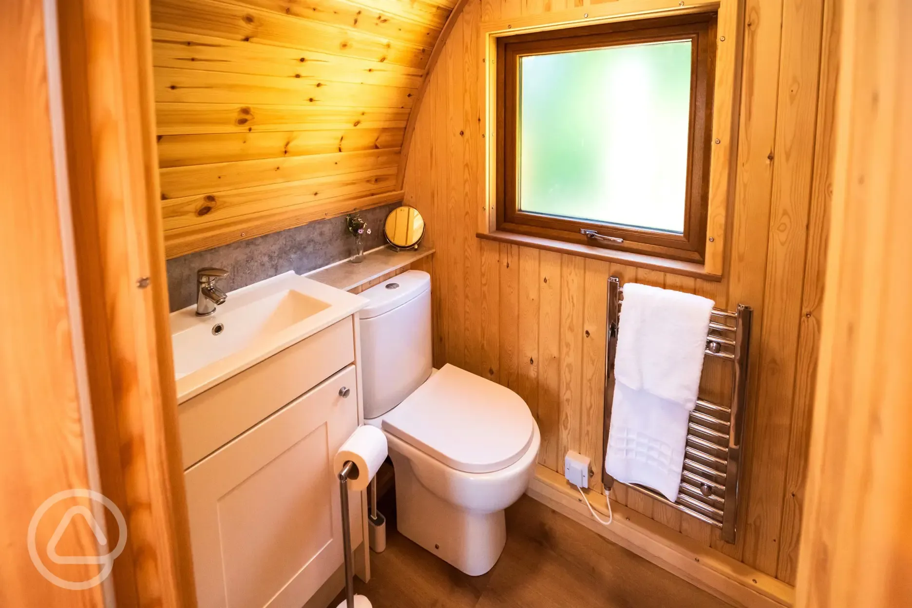 Ensuite glamping pod bathroom with toilet, sink, shower and heated towel rail