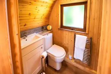 Ensuite glamping pod bathroom with toilet, sink, shower and heated towel rail Ensuite glamping pod bathroom with toilet, sink, shower and heated towel rail