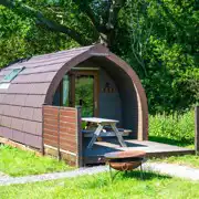Ensuite glamping pod exterior with outdoor bench seating and firepit Ensuite glamping pod exterior with outdoor bench seating and firepit