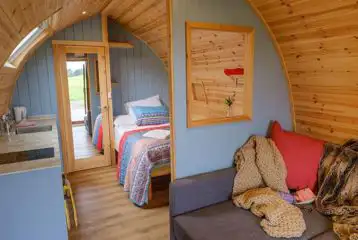 Ensuite glamping pod interior with double bed, kitchenette and living area Ensuite glamping pod interior with double bed, kitchenette and living area