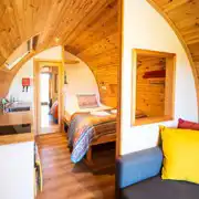 Ensuite glamping pod interior with double bed, kitchenette and living area Ensuite glamping pod interior with double bed, kitchenette and living area