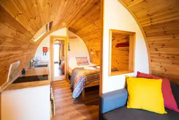 Ensuite glamping pod interior with double bed, kitchenette and living area Ensuite glamping pod interior with double bed, kitchenette and living area