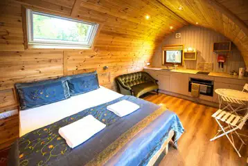 Primate pod interior with double bed, kitchenette and seating Primate pod interior with double bed, kitchenette and seating