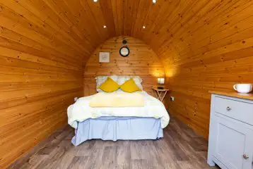 Camping pod interior with a double and bedding Camping pod interior with a double and bedding