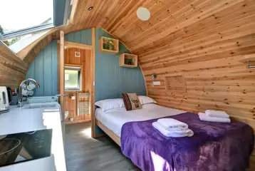 Glamping pod interior with a king size bed, bedding, towels and ensuite Glamping pod interior with a king size bed, bedding, towels and ensuite