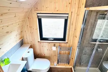 Ensuite with a flushing toilet, shower, hand basin and a heated towel rail