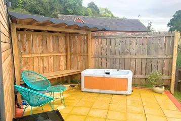 Owl glamping pod outside area with a hot tub