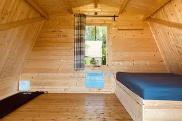 Camping pod interior with a double bed and camp beds (bring bedding)