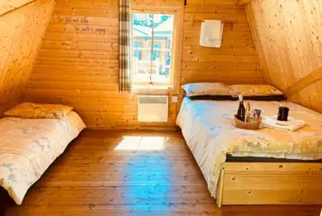 Camping pod interior with a double bed and camp beds (bring bedding)