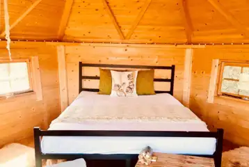 Hyssop glamping cabin with a double bed, cooking utensils and crockery