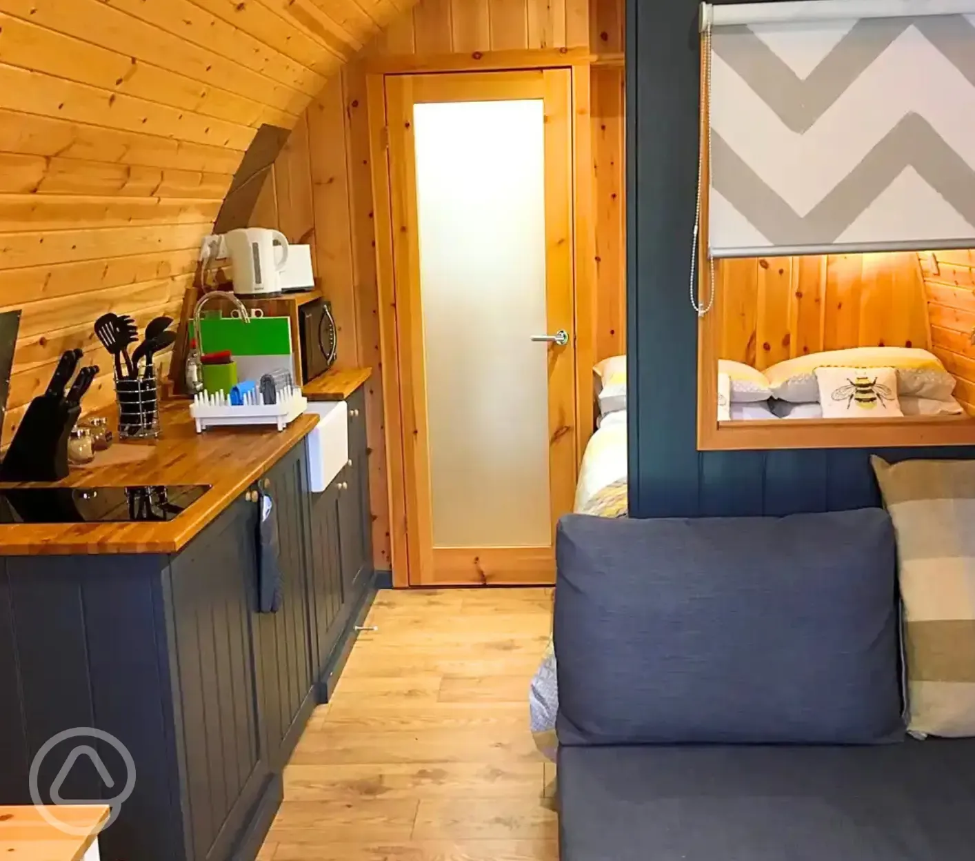 Pod interior with lounge area, bed, kitchenette and door to the ensuite bathroom Pod interior with lounge area, bed, kitchenette and door to the ensuite bathroom