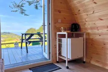 Camping pod with sea views with a fridge, kettle, and outdoor seating