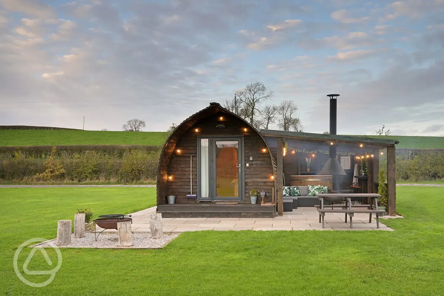 Exterior of the glamping pods with fire pits, hot tubs, and private patios