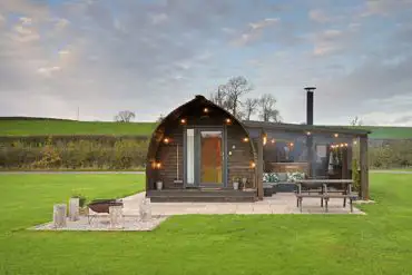 Exterior of the glamping pods with fire pits, hot tubs, and private patios