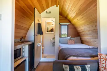 Glamping pod interior with a double bed, kitchen and ensuite Glamping pod interior with a double bed, kitchen and ensuite