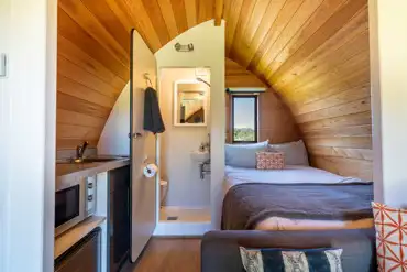 Glamping pod interior with a double bed, kitchen and ensuite