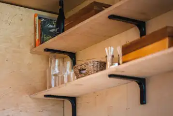 Glamping cabin kitchenette with gas stove, fridge and pans/utensils/crockery