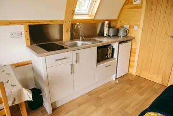 Glamping pod kitchen featuring a fridge/freezer, microwave, toaster, and kettle