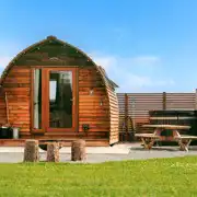 Ensuite glamping pod exterior with hot tub, fire pit and patio at Little Kelk