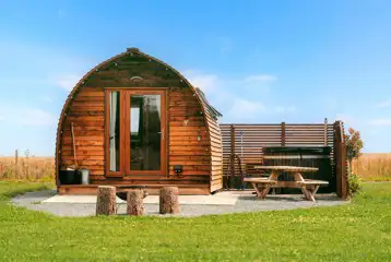 Ensuite glamping pod exterior with hot tub, fire pit and patio at Little Kelk