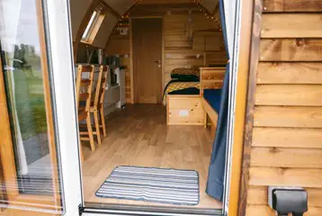 View into the ensuite glamping pod with seating, a double bed, and kitchenette