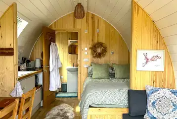 Bowcliffe pod interior with a double bed, bedding, kitchen and ensuite Bowcliffe pod interior with a double bed, bedding, kitchen and ensuite