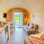 Cuddfan ensuite pod with a sofa bed, kitchenette, dining area, and French doors