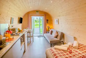 Cuddfan ensuite pod with a sofa bed, kitchenette, dining area, and French doors Cuddfan ensuite pod with a sofa bed, kitchenette, dining area, and French doors