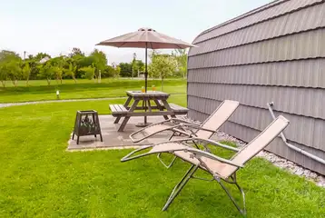 Glamping pods outside patio with a picnic bench, sun loungers, and fire pit Glamping pods outside patio with a picnic bench, sun loungers, and fire pit