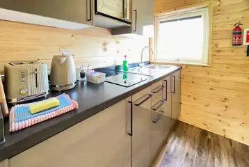 Carrock Squirrel Glamping Pod kitchen with a sink, kettle, toaster, and more