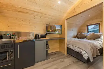 Carrock Sunset Glamping Pod kitchen area with a hob, fridge, and microwave