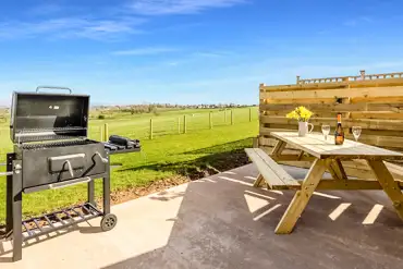 Private picnic bench and BBQ on outdoor patio with countryside views