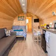 Glamping pod interior with double bed and double sofa bed for children