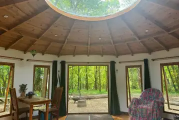 Roundhouse wooden yurt interior with a sky light