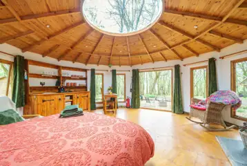 Roundhouse wooden yurt interior with a king size bed
