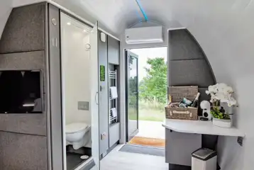 Glamping pod interior with an ensuite, TV, and coffee machine