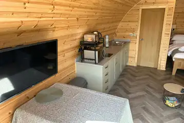 Ensuite glamping pod kitchenette, dining area, and TV Ensuite glamping pod kitchenette, dining area, and TV