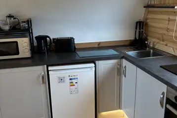 The Heron's Nest - kitchen area with a fridge, kettle, and microwave The Heron's Nest - kitchen area with a fridge, kettle, and microwave