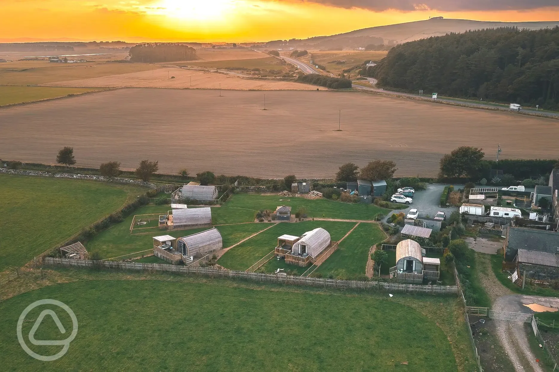 Aerial of The Galloway Steading at sunset, facing inland