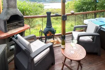 Private outdoor area with a BBQ, a chimenea and a hot tub with waterside views Private outdoor area with a BBQ, a chimenea and a hot tub with waterside views