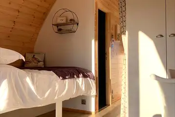 Pod interior with a double bed and dividing curtain Pod interior with a double bed and dividing curtain
